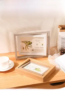 Close-up of a 5x7 inch rotating wooden photo frame with natural grain and plant artwork