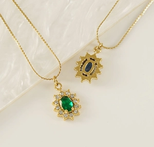 Detail of 18K gold stainless steel necklaces with green and blue oval zircon pendants