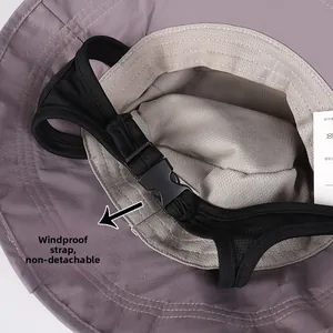 Detailed macro view of the non-removable windproof mesh chin strap on a nylon bucket hat