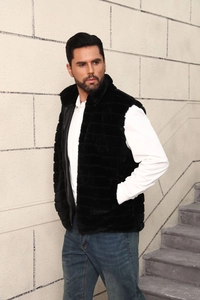 Detail of black faux fur vest with stand collar, worn over white shirt and jeans