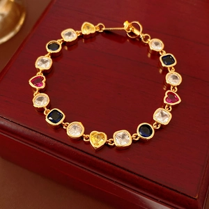Détail d'un bracelet vintage doré avec zircons multicolores en forme de cœur et carré