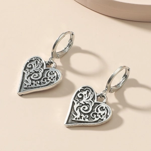 Vintage silver heart hoop earrings featuring intricate floral relief and bohemian hollow design