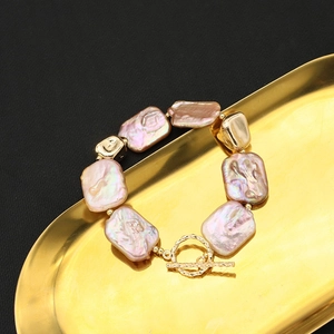 Baroque irregular pearl bracelet with 18k gold plated OT buckle on a luxury tray