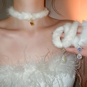 Detail of white faux fur choker with gold rocking horse and diamond pearl charms