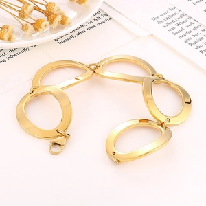 Polished gold stainless steel bracelet with chunky oval links on white aesthetic background