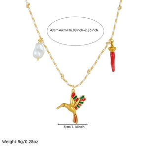 Detail view of woven chain necklace featuring a baroque pearl, enamel hummingbird and horn charm