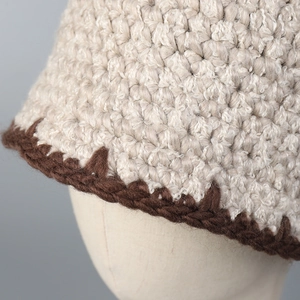 Detailed macro view of the handmade crochet knit texture and brown scalloped trim