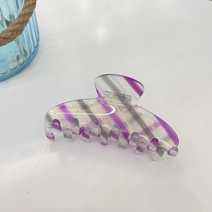 Macro shot of purple striped acetate claw clip with detailed silver metal spring