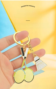 Détail de porte-clés raquette de badminton avec pendentif volant tenu dans la main
