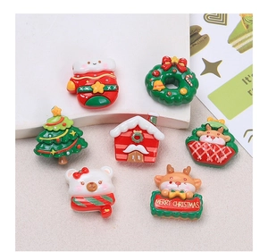 Flat lay of seven festive Christmas resin charms including reindeer and gingerbread house