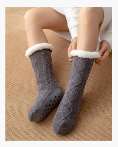 Close-up of grey thermal slipper socks with plush white cuff and non-slip sole grip