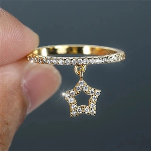 Elegant gold star pendant ring with sparkling pavé diamonds shown on finger