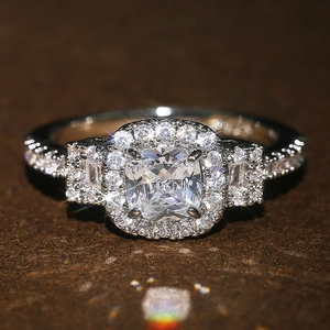 Classic silver-toned ring with a cushion-cut center stone and pave-set zircons on the band