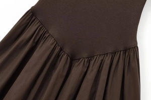 Detail of dark brown ribbed knit fabric joined with pleated woven material on dress