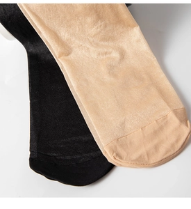 Macro shot of reinforced toe seams on glossy black and nude sheer pantyhose