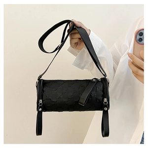 Detail of a black cylinder crossbody bag with wrinkled texture and wide fabric strap