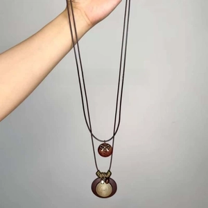 Detailed macro view of bohemian double-layer wooden pendant with butterfly and spiral metal