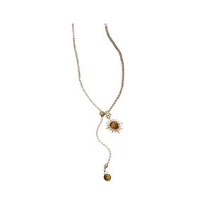 Collier doré bohème avec pierre œil de tigre et pendentif fleur de soleil sur fond blanc