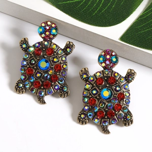 Vintage gold turtle earrings with colorful rhinestones on a white natural background
