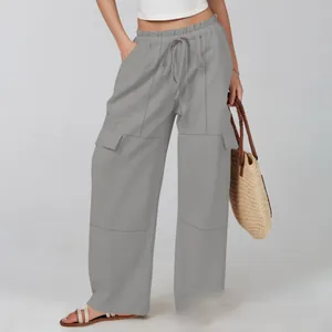 Detail of adjustable drawstring waistband and utility cargo pockets on gray wide-leg pants