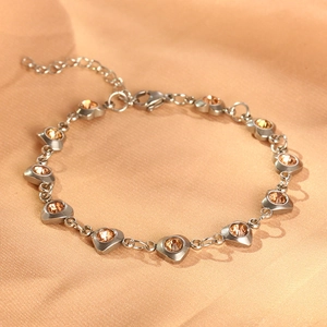 Detail of silver heart bracelet with amber crystals on silk, featuring lobster clasp