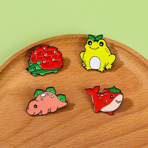 Set of four cute cartoon enamel pins with fruit and animal mashups on wooden plate