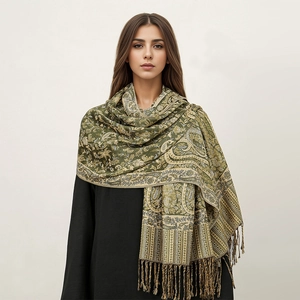 Detail of green pashmina shawl with ethnic paisley patterns and fringe tassels