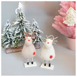 Close-up of handmade wool felt reindeer figurines with red star accents and rope antlers