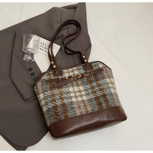 Detail of retro tote bag with brown leather and blue-grey plaid tweed texture