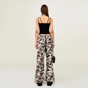 Rear view of slim fit black ribbed camisole and camo cargo pants on a model