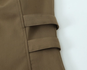 Close-up of brown twill fabric with decorative double straps and detailed stitching