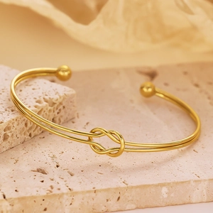 Detailed macro view of 18k gold plated stainless steel knot bracelet on stone