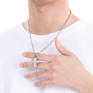 Detail of silver cross pendant with cubic zirconia inlay on male model with white shirt