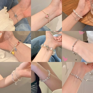Collection of nine minimalist pearl bracelets with gold and silver charms for women