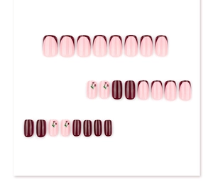 Detail of short square press-on nails featuring burgundy, pink, and cherry patterns