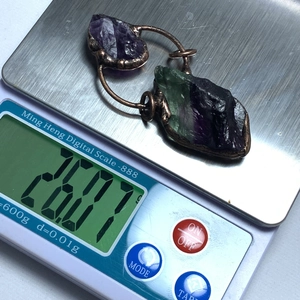 Primer plano del colgante de cristal artesanal en una báscula digital pesando 26,07g