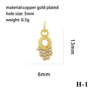 Macro detail of 18K gold plated Hand of Fatima pendant with zircon and 5mm hole