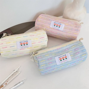 Detalle de estuches de tweed de colores en tonos rosa, crema y azul claro