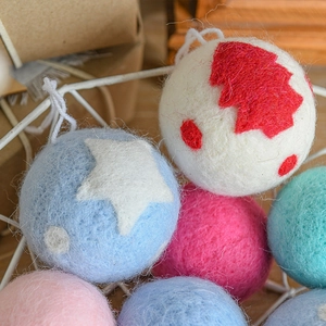 Handmade wool felt Christmas tree ornaments with star and tree patterns in wire basket