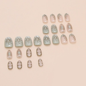 Short square press-on nails with light green sun cat eye pattern and metallic accents