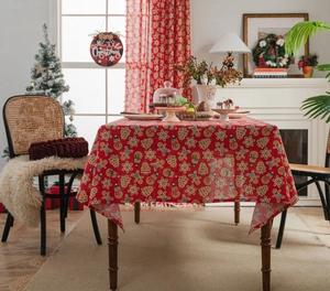 Detail of red Christmas tablecloth with gingerbread man and snowflake prints in a dining room