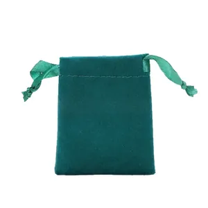Dark green velvet jewelry drawstring bag with satin ribbons on white background