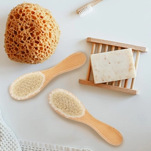 Detail view of baby bath set with wool brushes, natural sponge and soap on wooden holder