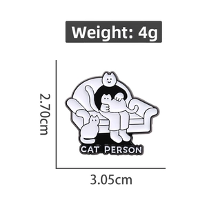 Cute black and white Cat Person enamel pin featuring a cozy person holding two cats