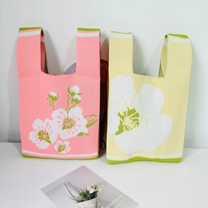 Detail shot of the soft knitted texture and floral pattern on pink and yellow tote bags