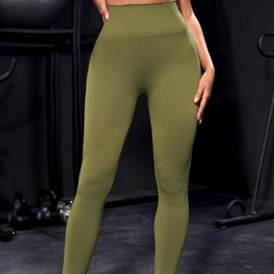 Leggings da yoga senza cuciture a vita alta verde oliva per donna in una palestra