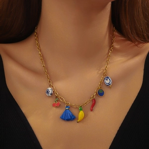 Gold chain necklace with colorful acrylic vegetable and cherry charms on a fashion model