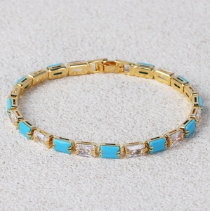 Detailed shot of a gold-plated bracelet featuring turquoise and clear cubic zirconia