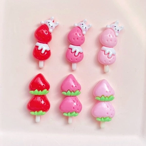 Flat lay of strawberry rabbit resin charms in red and pink for DIY crafts and hair clips