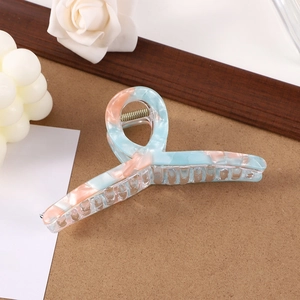Minimalist light blue and pink marble pattern hair claw clip on wooden background